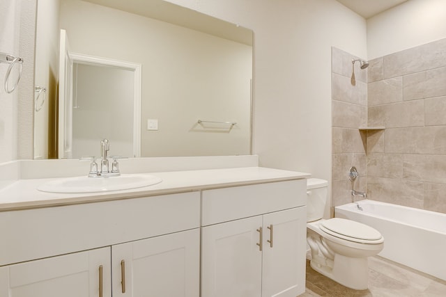 full bathroom featuring tiled shower / bath, vanity, and toilet