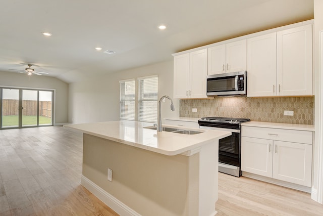 kitchen featuring sink, white cabinetry, a center island with sink, appliances with stainless steel finishes, and decorative backsplash