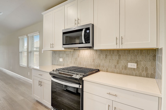 kitchen featuring decorative backsplash, light hardwood / wood-style floors, white cabinets, and appliances with stainless steel finishes