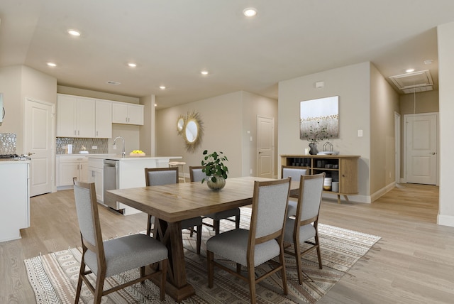 dining space with sink and light wood-type flooring