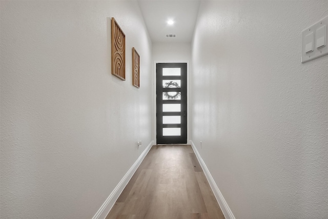 doorway to outside with wood-type flooring