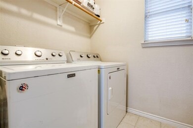 washroom with light tile patterned floors and washer and clothes dryer