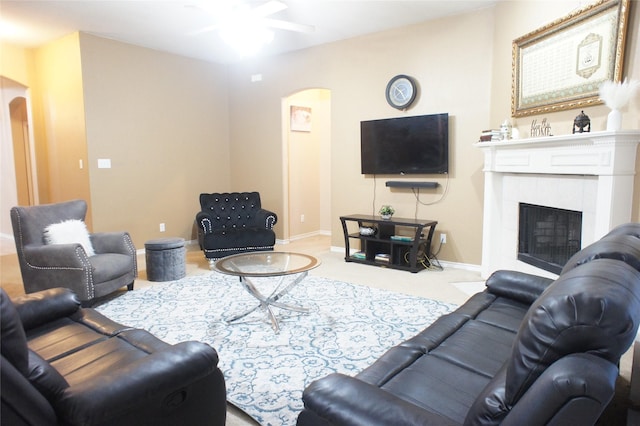 carpeted living room with ceiling fan and a fireplace