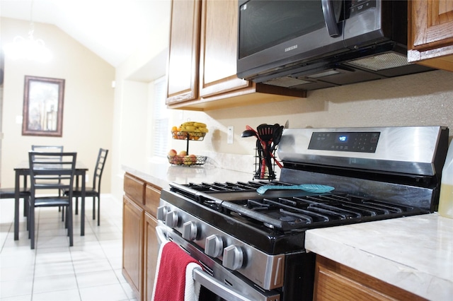 kitchen featuring vaulted ceiling, stainless steel range with gas cooktop, and light tile patterned floors