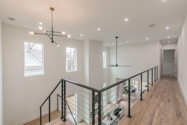 hallway featuring light hardwood / wood-style flooring and a chandelier