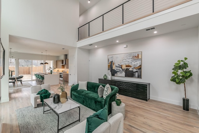 living room featuring light hardwood / wood-style flooring and a high ceiling