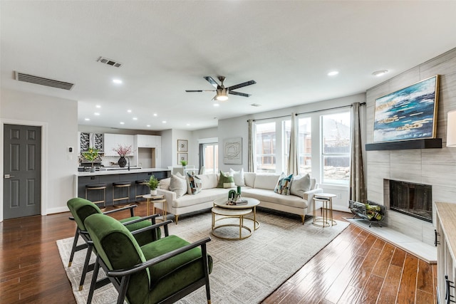 living room with ceiling fan and a fireplace