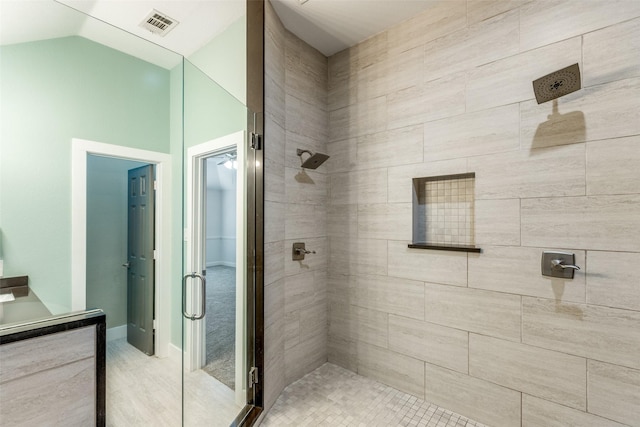 bathroom featuring vaulted ceiling and a shower with door