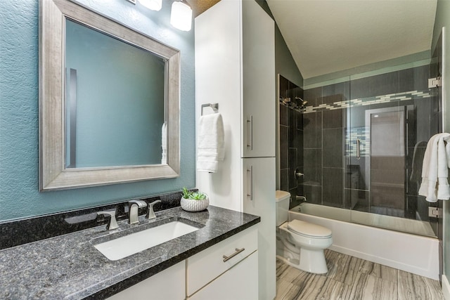 full bathroom featuring lofted ceiling, vanity, enclosed tub / shower combo, and toilet