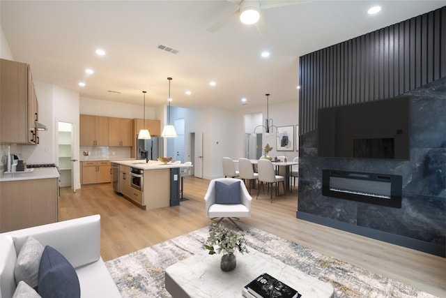 living room with ceiling fan and light wood-type flooring