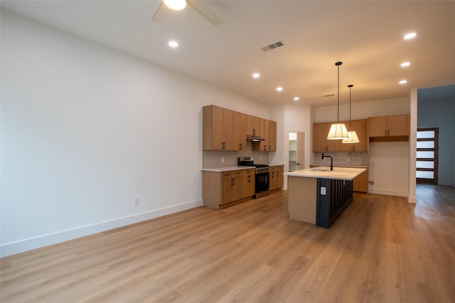 kitchen with tasteful backsplash, pendant lighting, a center island with sink, and stainless steel range