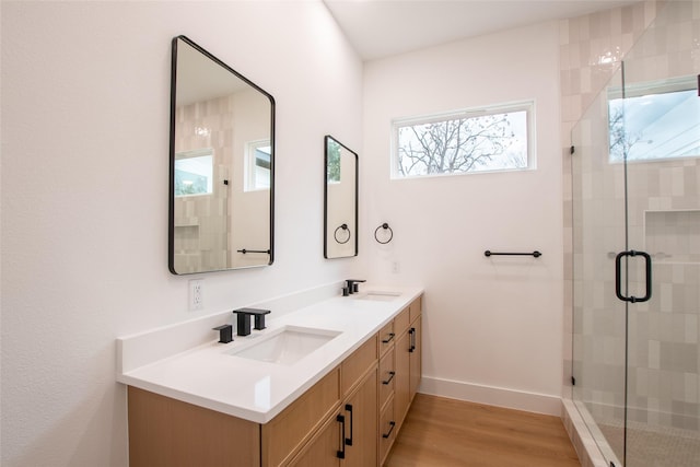 bathroom with wood-type flooring, an enclosed shower, and vanity