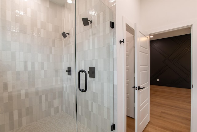 bathroom with hardwood / wood-style flooring and a shower with door