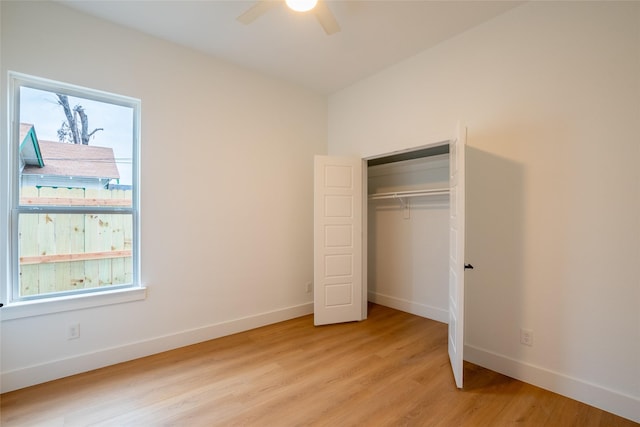 unfurnished bedroom featuring multiple windows, light hardwood / wood-style flooring, a closet, and ceiling fan