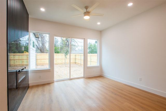 empty room with ceiling fan and light hardwood / wood-style floors