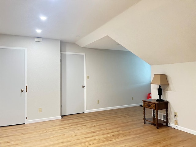 bonus room with lofted ceiling and light hardwood / wood-style floors