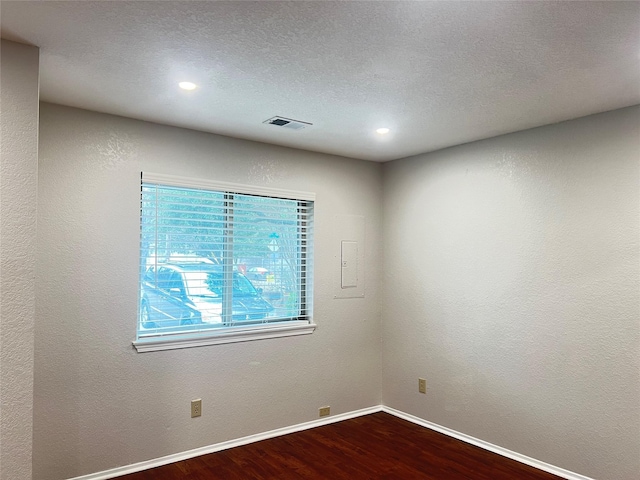 unfurnished room with hardwood / wood-style floors and a textured ceiling