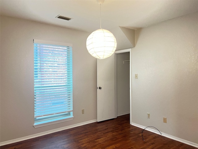 unfurnished room with plenty of natural light and dark hardwood / wood-style flooring