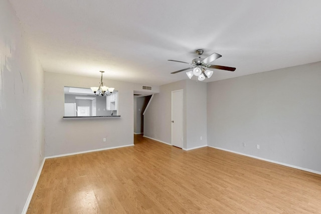 unfurnished room with ceiling fan with notable chandelier and hardwood / wood-style floors