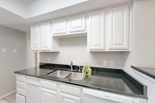 kitchen with light tile patterned flooring, white dishwasher, sink, and white cabinets