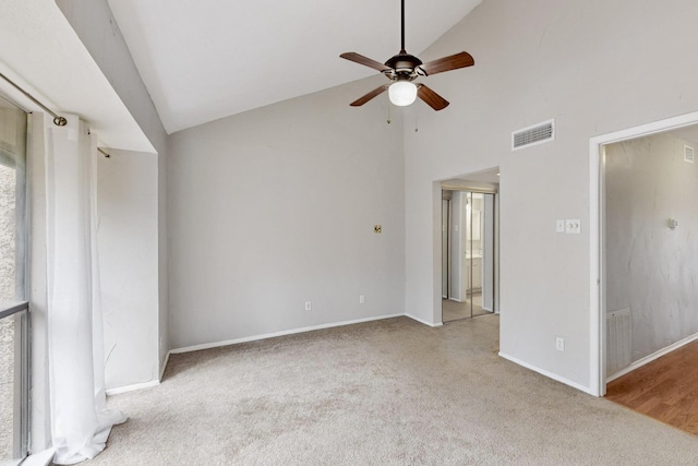 carpeted spare room with high vaulted ceiling and ceiling fan