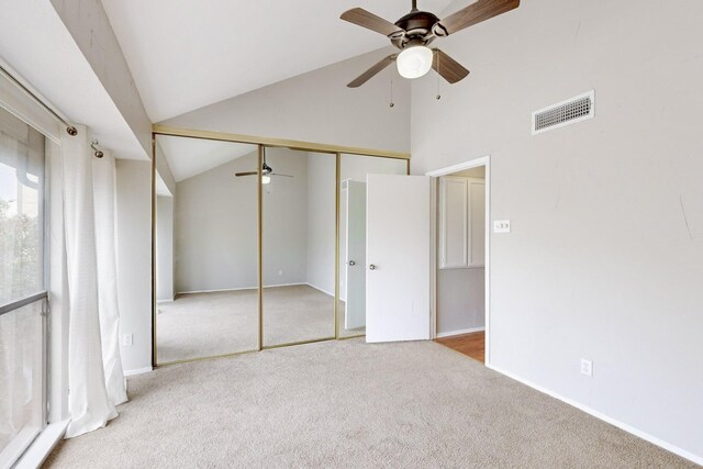 carpeted spare room featuring lofted ceiling and ceiling fan