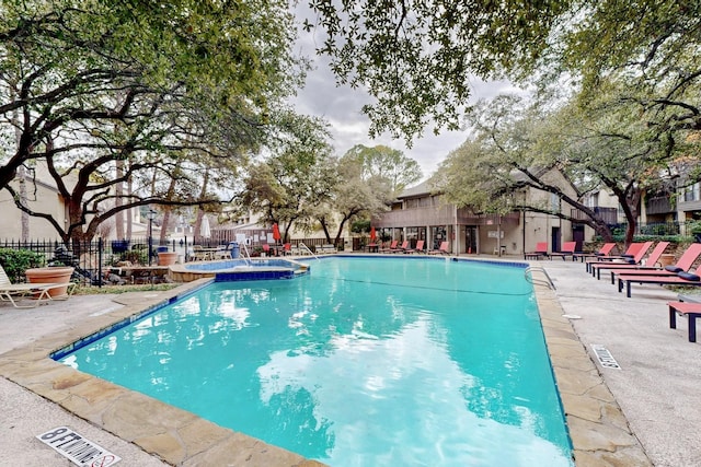 view of pool featuring a hot tub and a patio