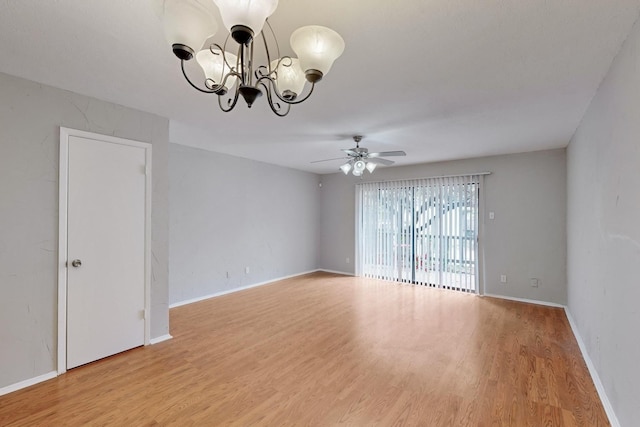 unfurnished room featuring ceiling fan with notable chandelier and hardwood / wood-style floors