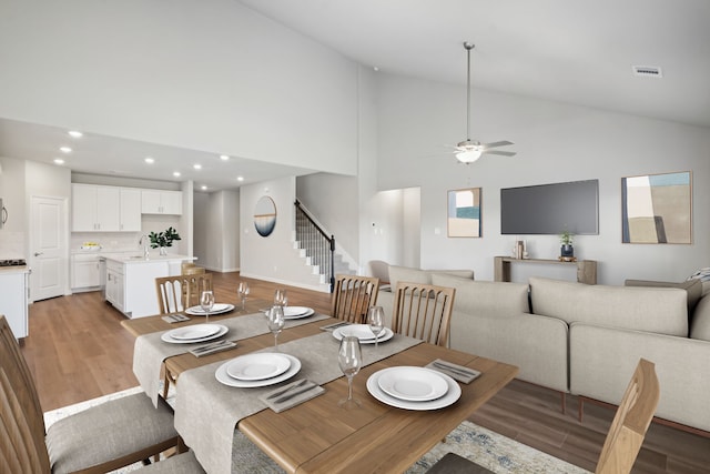 dining area with sink, light hardwood / wood-style flooring, high vaulted ceiling, and ceiling fan