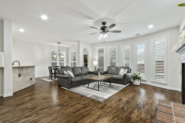 living room featuring plenty of natural light, dark hardwood / wood-style floors, and ceiling fan with notable chandelier