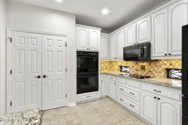 kitchen with white cabinetry, tasteful backsplash, light stone counters, and black appliances