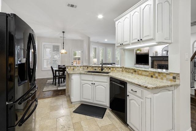 kitchen featuring sink, white cabinetry, hanging light fixtures, kitchen peninsula, and black appliances