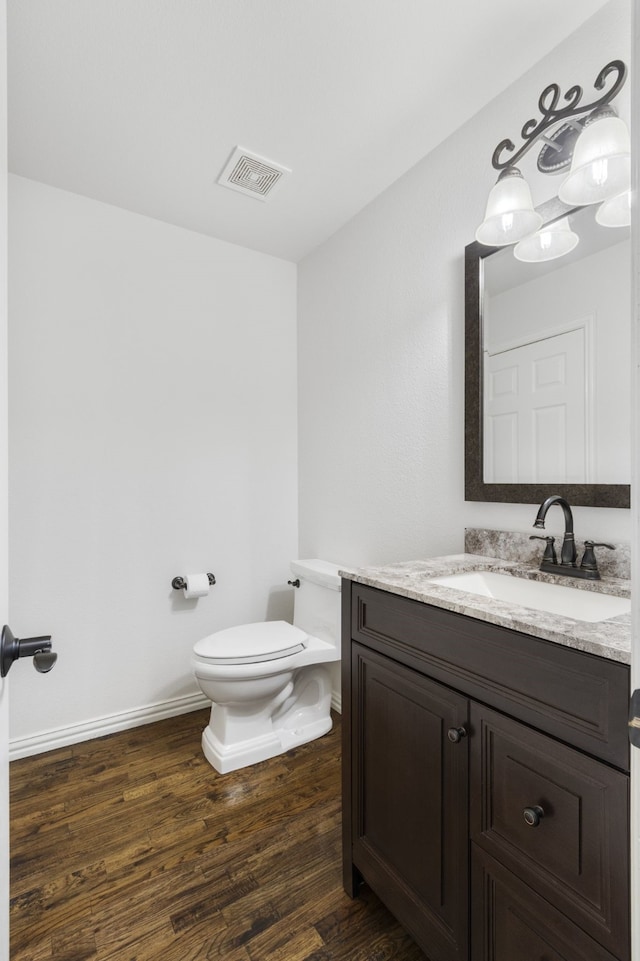 bathroom featuring vanity, hardwood / wood-style floors, and toilet