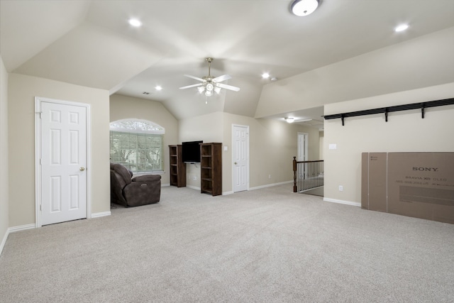 unfurnished living room featuring ceiling fan, light colored carpet, and vaulted ceiling