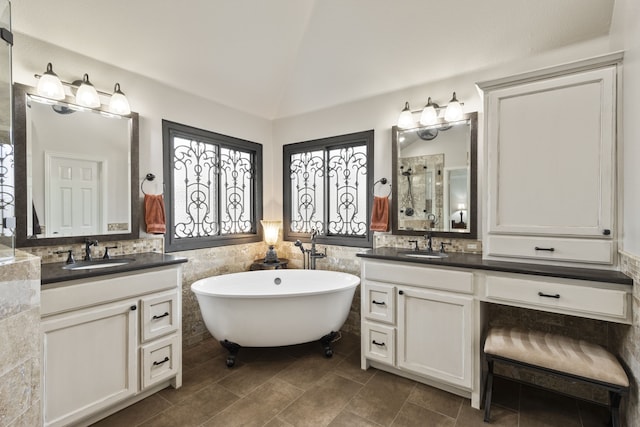 bathroom featuring vanity, lofted ceiling, tile walls, and separate shower and tub