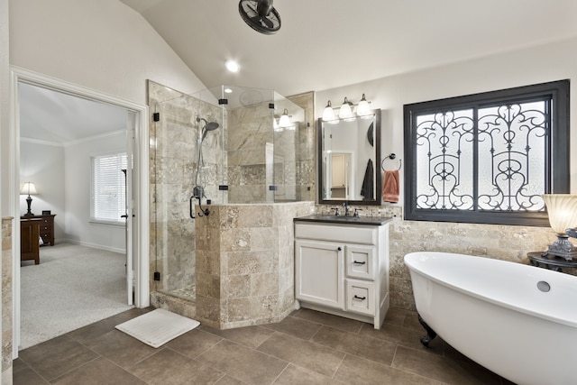 bathroom with vanity, vaulted ceiling, and independent shower and bath