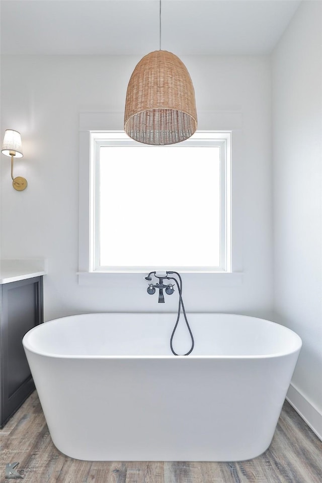 bathroom featuring hardwood / wood-style flooring, a wealth of natural light, and a bathtub