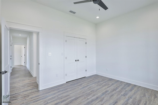 unfurnished bedroom featuring light hardwood / wood-style flooring, ceiling fan, and a closet