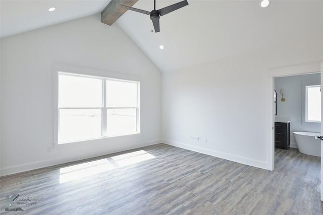 unfurnished living room with beam ceiling, high vaulted ceiling, ceiling fan, and light hardwood / wood-style floors