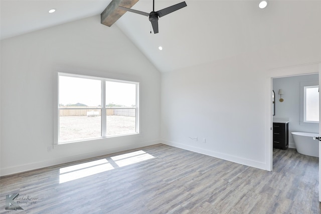 unfurnished living room featuring beam ceiling, high vaulted ceiling, ceiling fan, and light wood-type flooring