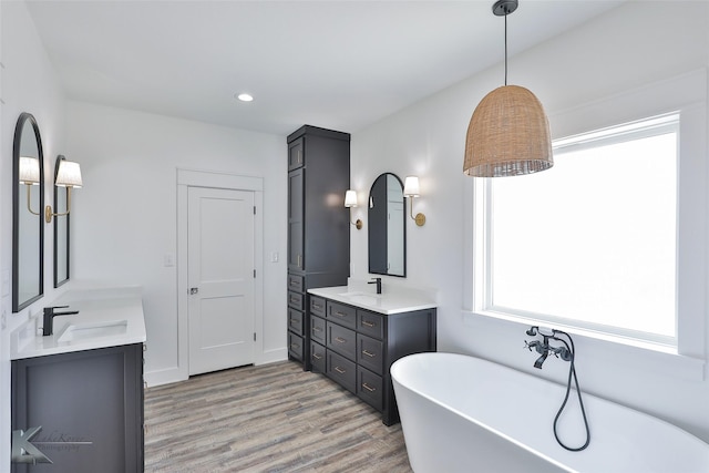 bathroom with vanity, a bath, and hardwood / wood-style flooring