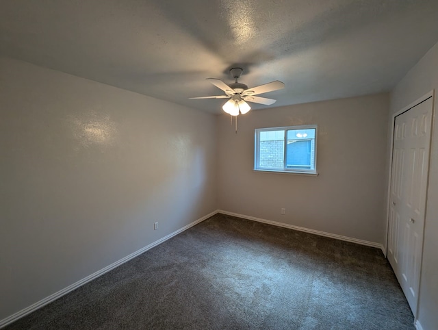 unfurnished bedroom with a textured ceiling, a closet, ceiling fan, and dark colored carpet