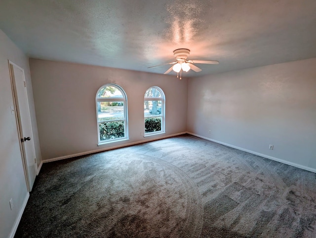 carpeted empty room featuring ceiling fan and a textured ceiling