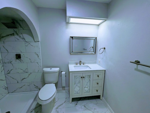 bathroom with vanity, toilet, and a tile shower