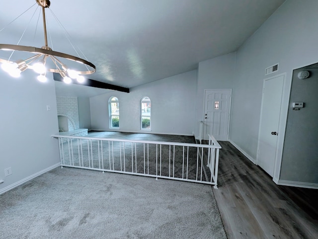 carpeted spare room featuring vaulted ceiling with beams