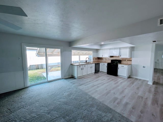 kitchen with white cabinetry, sink, light wood-type flooring, and black appliances