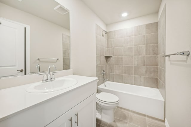 full bathroom featuring tiled shower / bath, vanity, tile patterned floors, and toilet