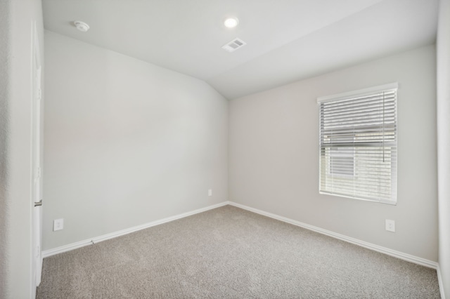 spare room featuring lofted ceiling and carpet floors