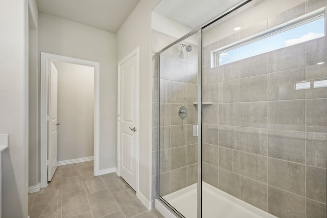 bathroom with an enclosed shower and tile patterned flooring