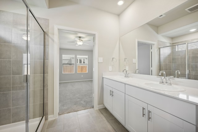 bathroom with ceiling fan, vanity, and a shower with door